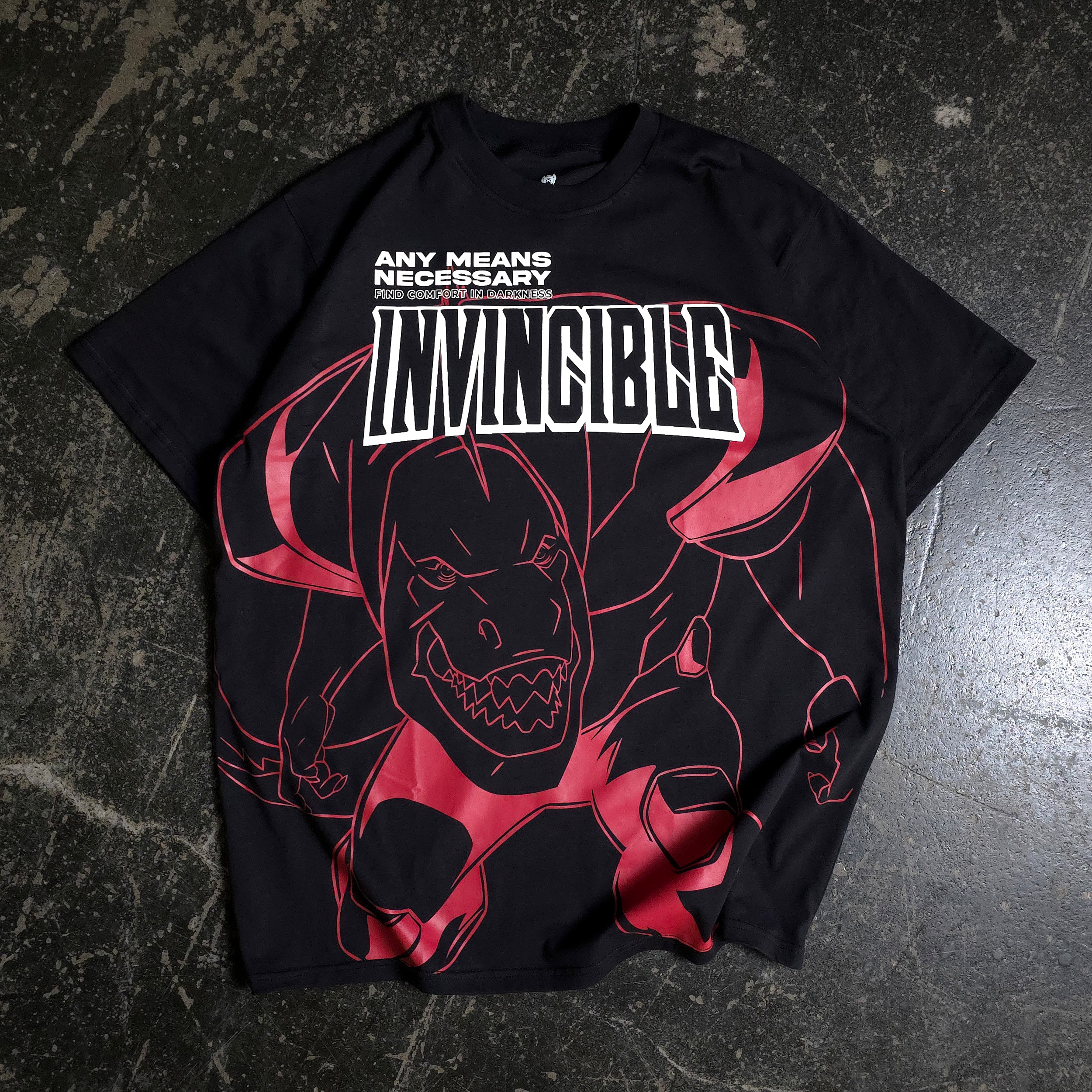 A black t-shirt with a red line art dinosaur graphic and the text Invincible on the front.