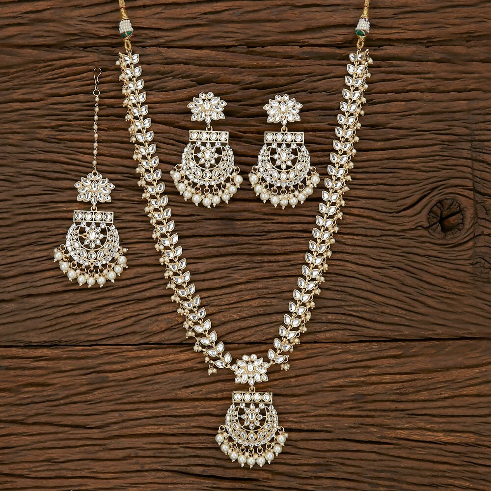 4-piece Golden White necklace set with Kundan, pearls, and Onyx stones for traditional weddings.