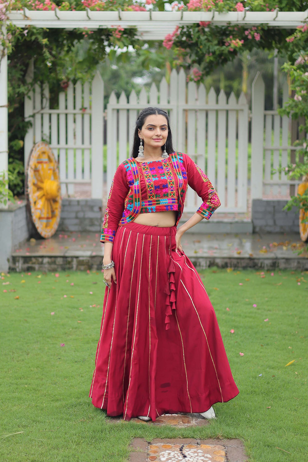 A stunning maroon Roman Silk lehenga choli adorned with intricate Gota-Patti lace work for festive occasions.