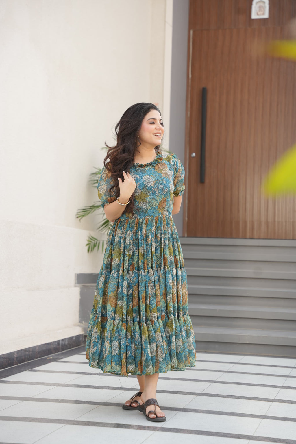 Woman wearing a light blue printed faux georgette flared gown with 12-meter hem