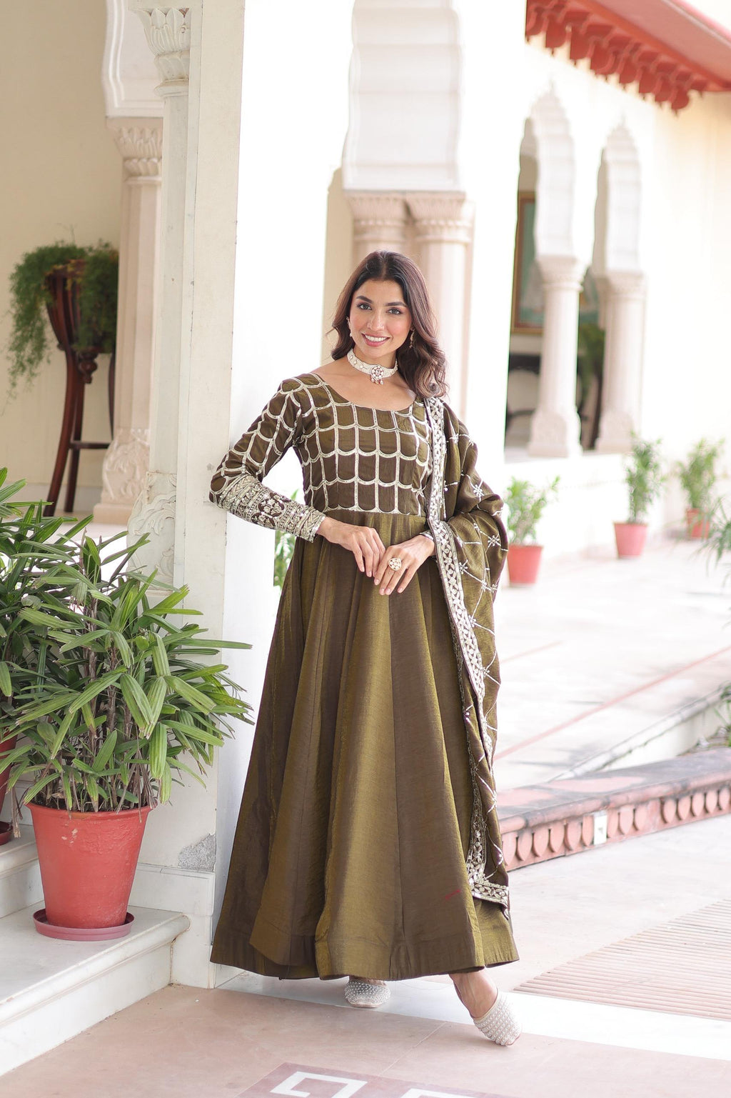 Mahendi colored Vichitra silk gown with detailed zari embroidery and sequins, featuring a flared skirt and long sleeves.