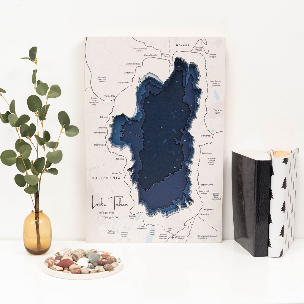 Coastal navy-blue and off-white wooden map of Lake Tahoe, 18x24 inches, displayed on a neutral interior wall.