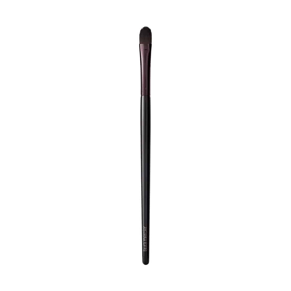 Close up of a black and brown rounded synthetic crème eye color makeup brush.
