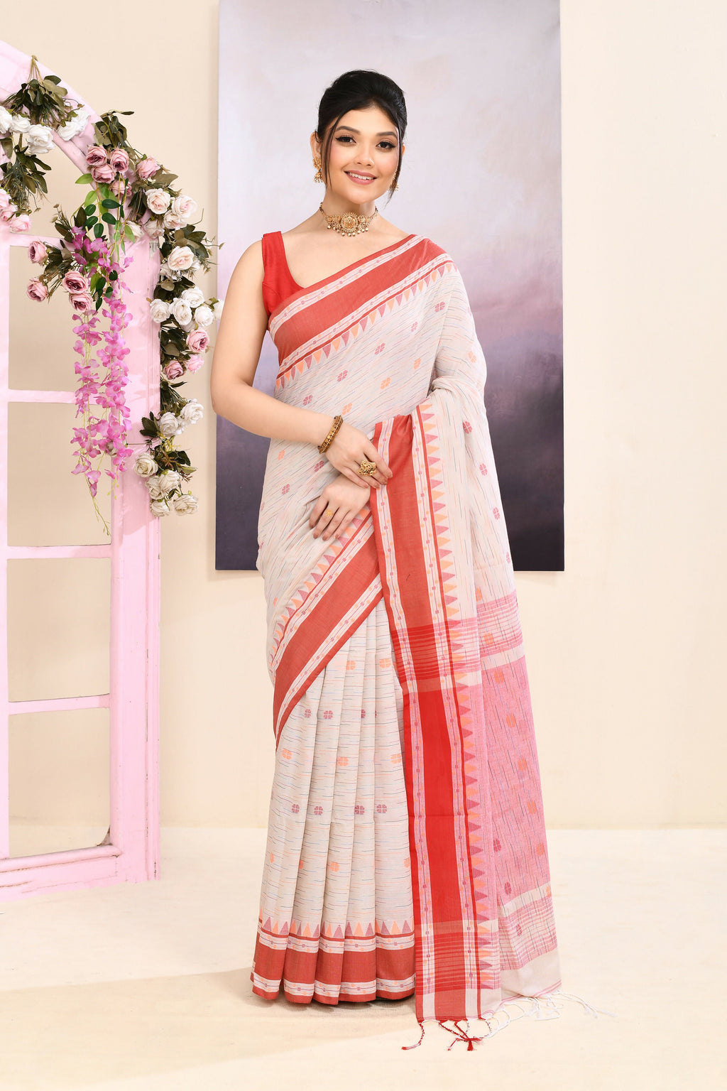 Woman wearing a beige embellished cotton saree with intricate detailing