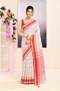 Woman wearing a beige embellished cotton saree with intricate detailing