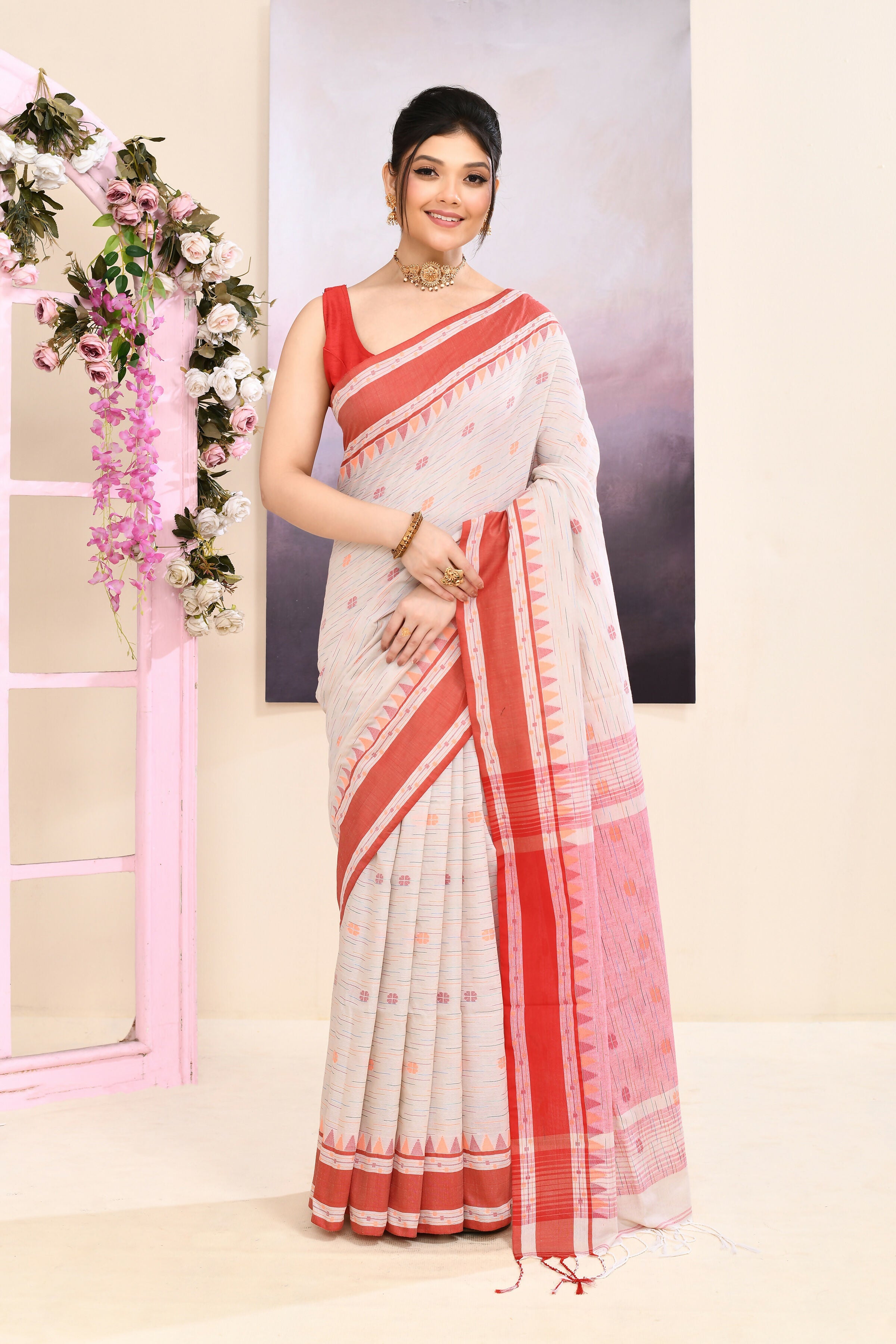 Woman wearing a beige embellished cotton saree with intricate detailing
