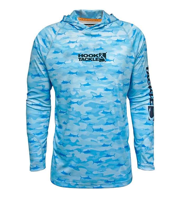 A man wearing a blue billfish camouflage long sleeve fishing hoodie with a hood, white shorts, and black sneakers.