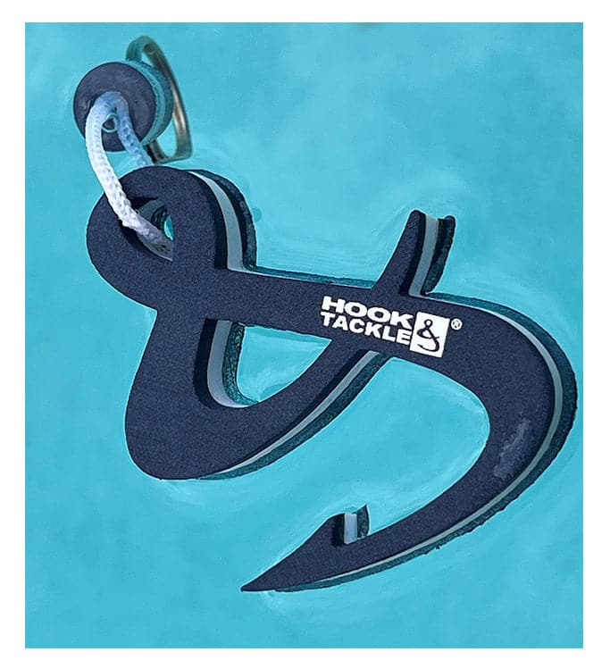 Dark navy and white foam floating keychain shaped like a hook and ampersand logo floating on blue water
