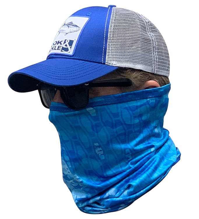 A person wearing a blue patterned fishing neck gaiter and a baseball cap.