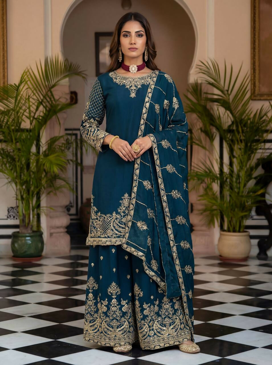 A beautiful teal silk embroidered kurti paired with a sharara.