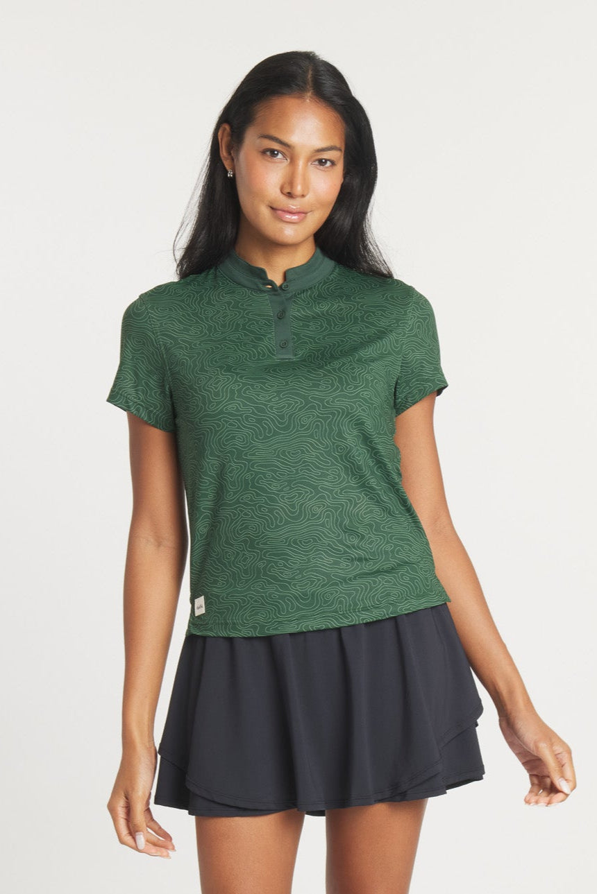 Woman wearing a green Catalyst Polo with a topographic print and mock collar.