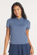 A woman wearing a Raindrop blue Catalyst Polo with a mock collar, shown from the front and back against a neutral background.