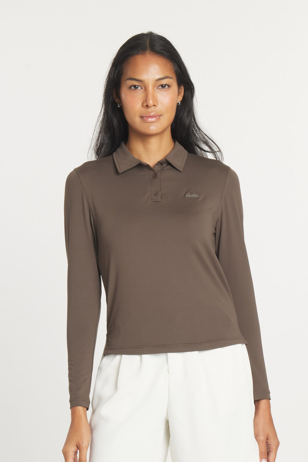 A woman wearing a long sleeve, brown, point collar Catalyst Polo shirt by Mantra.
