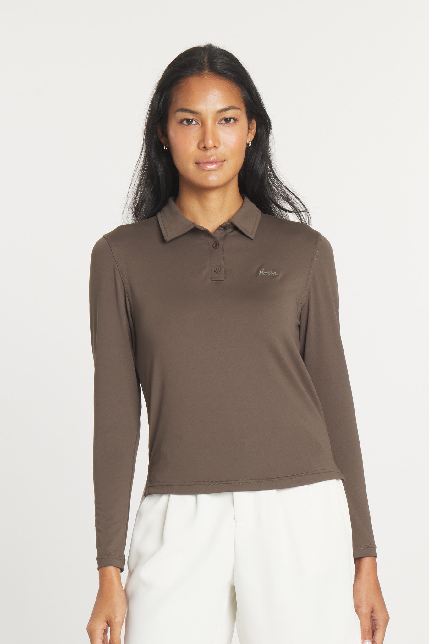 A woman wearing a long sleeve, brown, point collar Catalyst Polo shirt by Mantra.