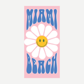 Pink beach towel with a white daisy smiley face and blue Miami Beach text.