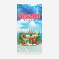 A rectangular beach towel featuring a colorful design of tropical cocktails, pineapple, and palm leaves against a bright Miami beach backdrop with blue sky and sea.
