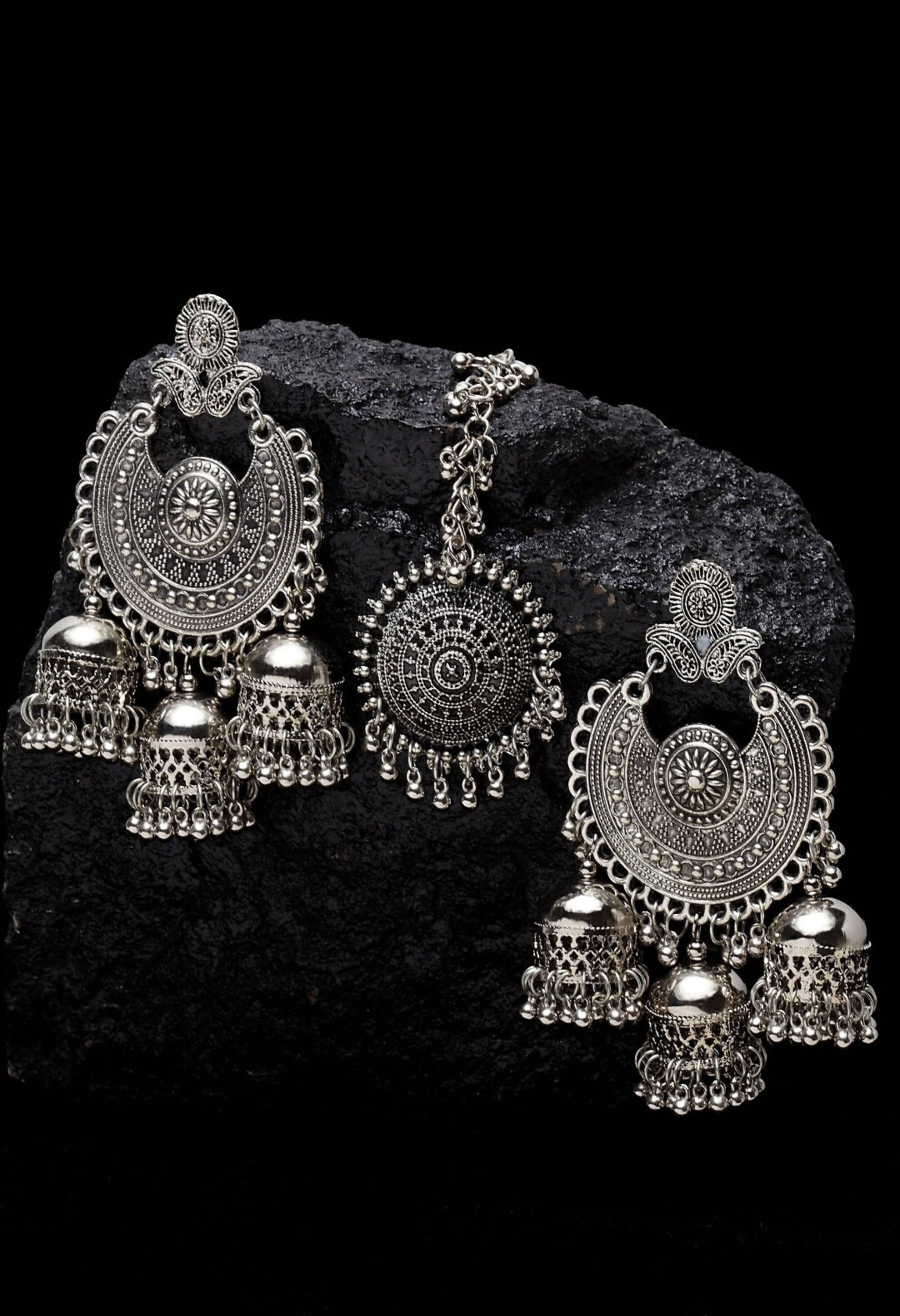 Silver jhumka earrings and matching maang tikka with intricate ethnic designs