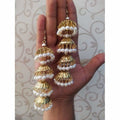 Traditional gold-polished latkan jhumka earrings featuring white pearl embellishments