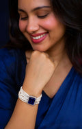 Close up of a blue Monalisa stone beaded bracelet with brass accents on a neutral background