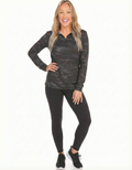 A woman wearing a long-sleeve black camo patterned quarter zip top with black leggings.