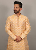 Men's light yellow silk kurta featuring an intricate jacquard pattern and heavy neck embroidery detail.