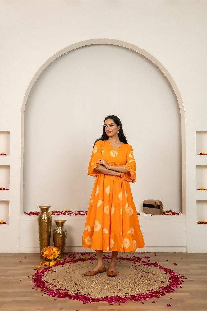 Woman wearing an orange cotton dress with a tie-dye pattern