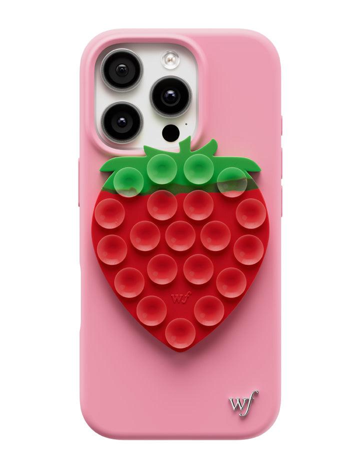 Strawberry-shaped MagSafe phone grip on a pink and black phone case