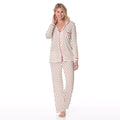 Woman wearing a women's long sleeve collared pajama set in a white and red heart print pattern.