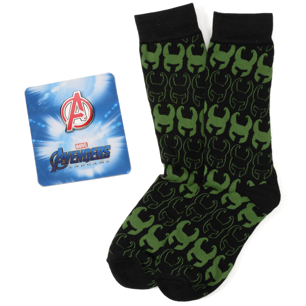 A pair of black and green Loki helmet pattern socks next to a Marvel Avengers icon lapel pin.