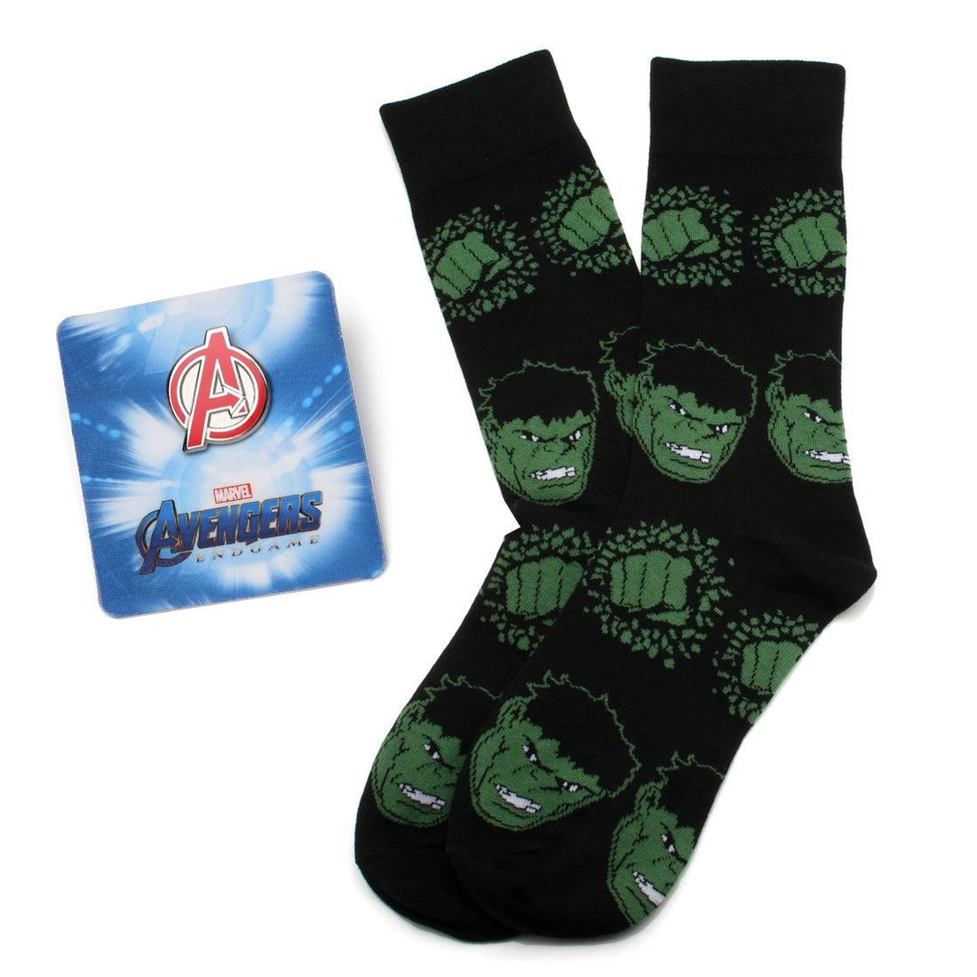 A pair of black crew socks with a repeating green Hulk face and fist pattern alongside a silver and red Avengers logo lapel pin.