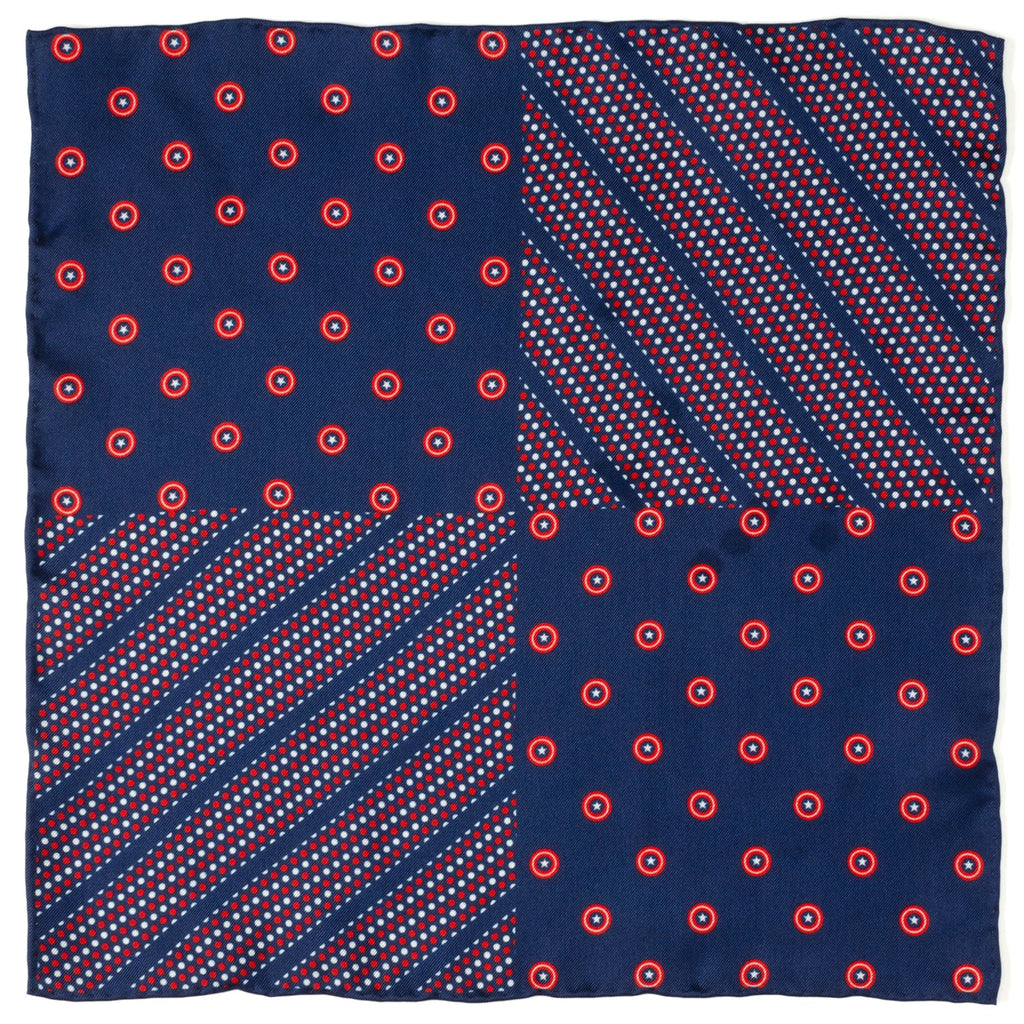 Close up view of a navy blue pocket square featuring red and white Captain America shield motifs tucked into a grey suit jacket pocket.