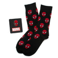 A Marvel Spider-Man gift set containing black socks with red Spiderman mask patterns and a matching Spiderman mask lapel pin on a black background.