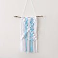 DIY bohemian wall hanging crochet kit featuring white and blue knit fabric, styled for a minimalist bedroom wall.