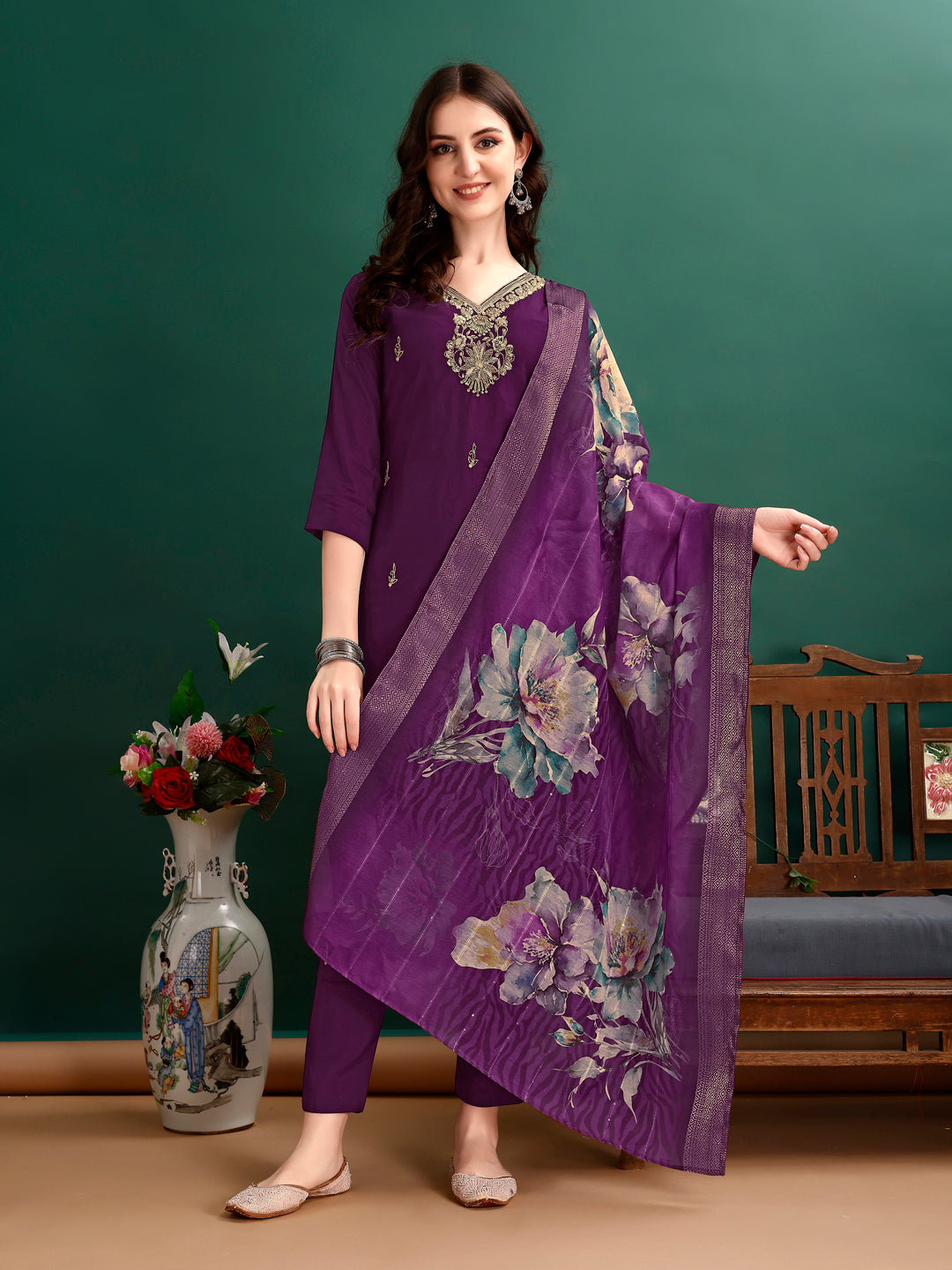 A woman wearing a vibrant multicolor hand embroidered rayon kurta set with an organza printed dupatta.