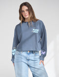 Model wearing a soft 100% cotton cropped long sleeve tee with a relaxed fit and dropped shoulders.