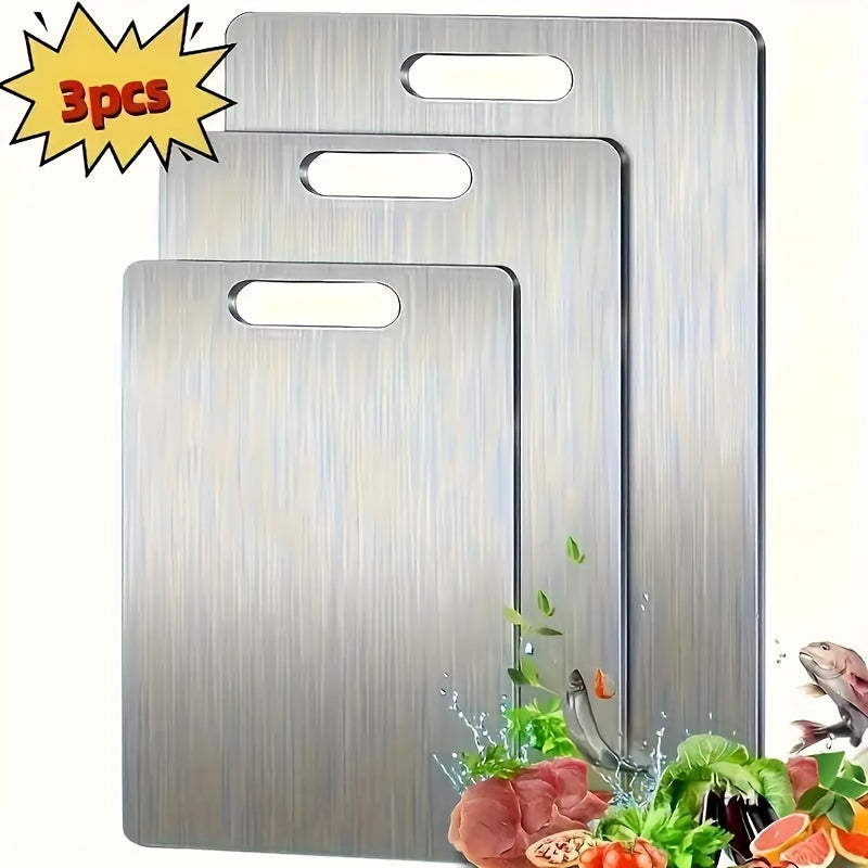 Set of three brushed stainless steel cutting boards in varying sizes for modern kitchen prep.