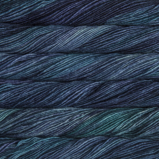 Skein of deep navy and teal Silky Merino yarn with a soft, lustrous sheen