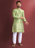 A man wearing a light green jacquard silk kurta with detailed Amboj embroidery.