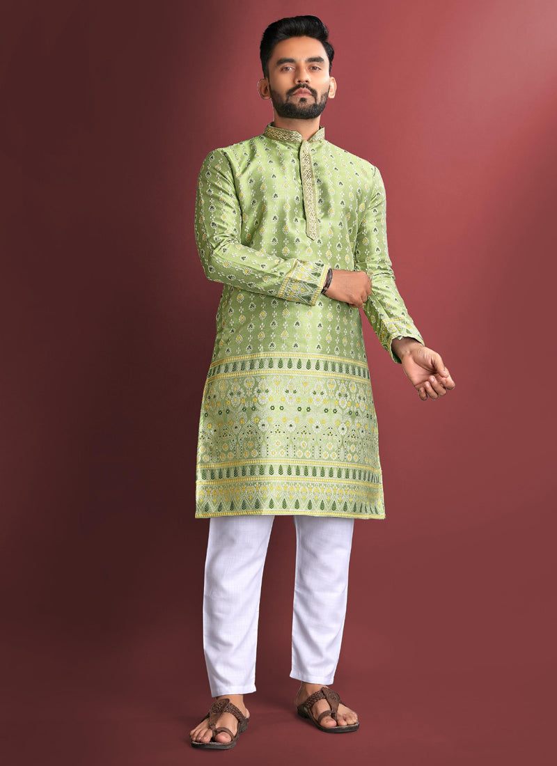 A man wearing a light green jacquard silk kurta with detailed Amboj embroidery.