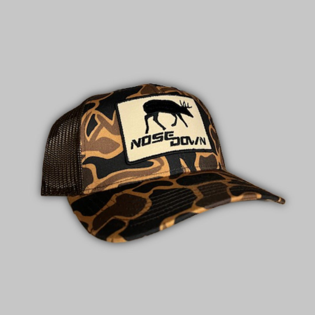 Maple Buck Trucker hat featuring Nose Down camo pattern and buck graphic on a snapback cap