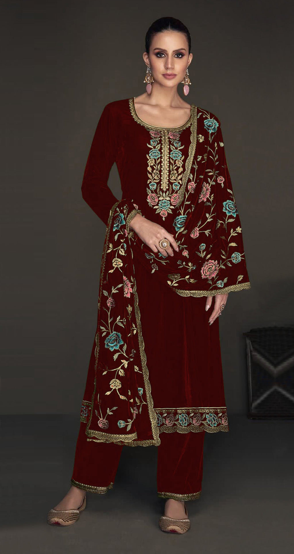 Close up of maroon velvet fabric with gold embroidery and sequence work