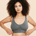 A woman wearing a grey front-closure cotton modal bralette, featuring a zip front and wide supportive straps.