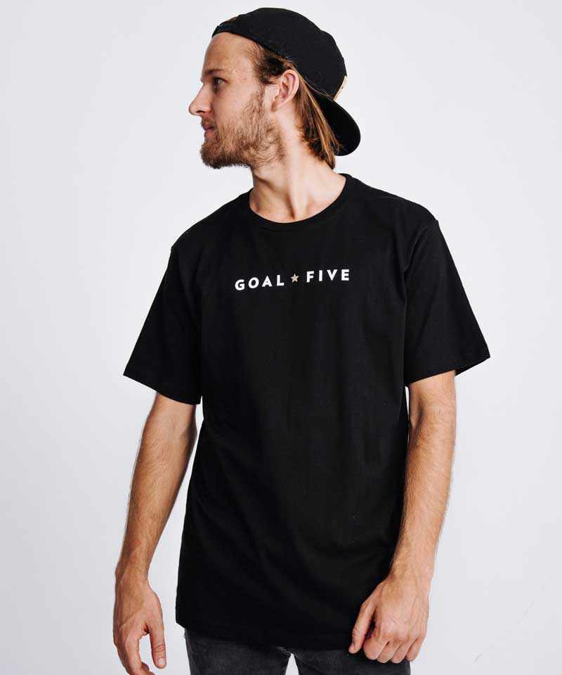 Model wearing a black men's t-shirt with Goal Five logo