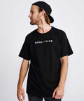 Model wearing a black men's t-shirt with Goal Five logo