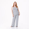 A woman wearing a soft heathered mist grey spaghetti strap cami and matching wide-leg lounge pants set standing against a white background.