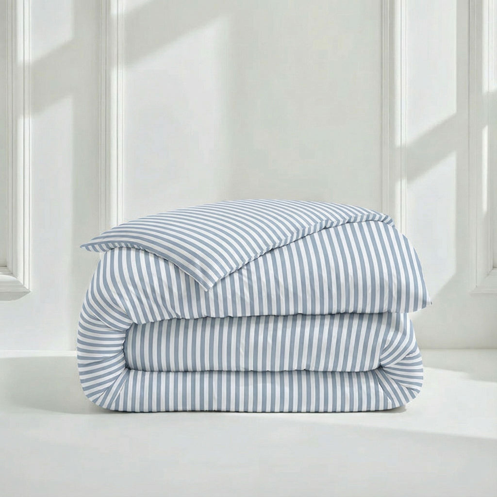 Folded stack of Australian Cotton Sateen Duvet Covers showing striped and solid lavender options in a bright, clean bedroom setting.