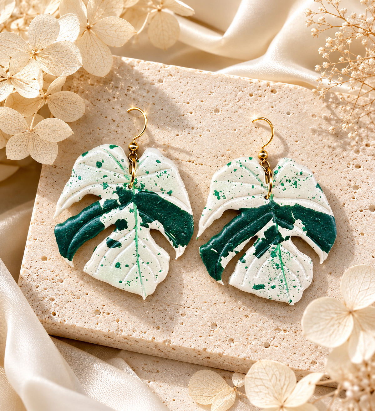 Abstract Monstera Bulbasaur polymer clay earrings in green and white.