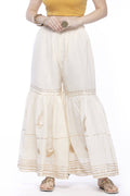 Off-white cotton sharara pants featuring intricate gold gota work detailing.