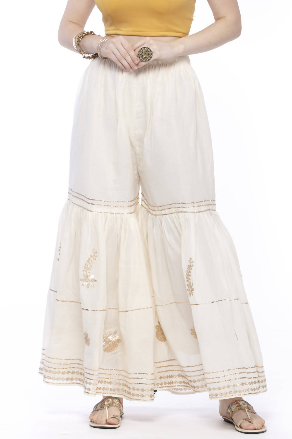 Off-white cotton sharara pants featuring intricate gold gota work detailing.