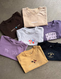 A variety of kids' oversized cotton tees in assorted solid colors folded neatly